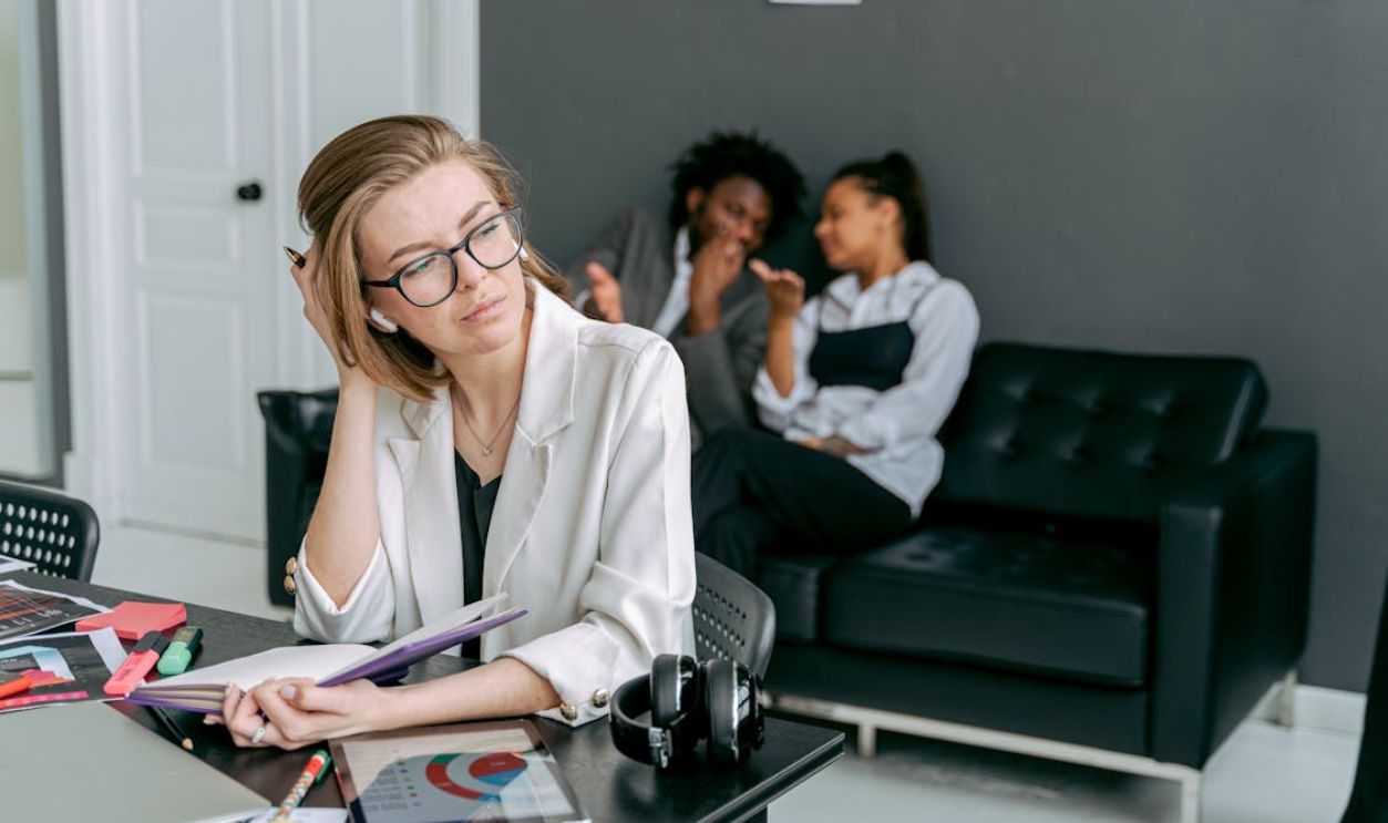 Photo of a Woman in a White Blazer Touching Her Hair