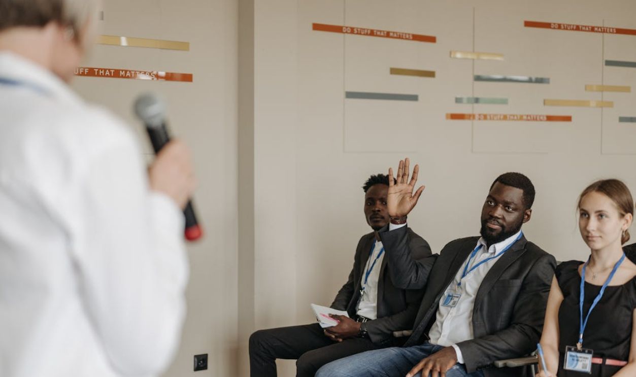 Men and Woman Sitting in Auditorium at Business Conference
