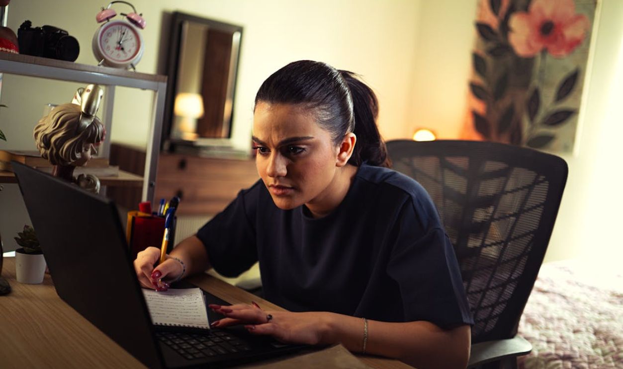 Focused Woman Studying on Laptop at Desk