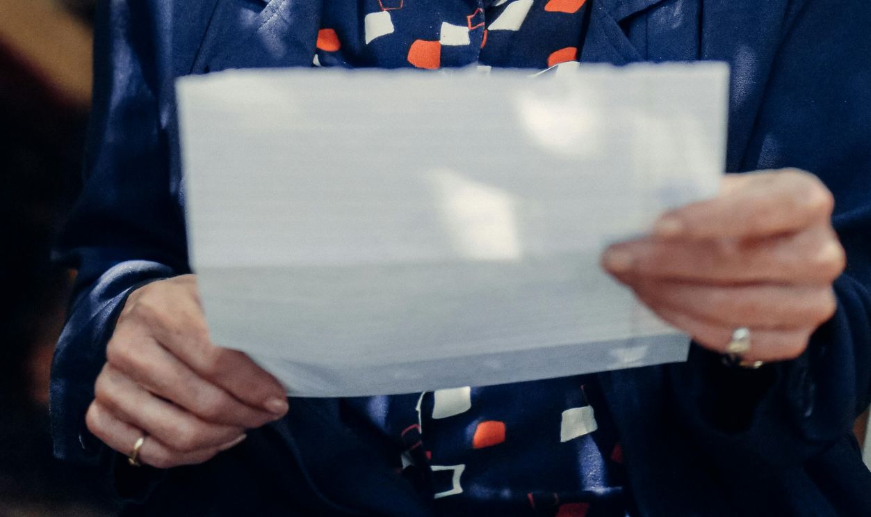 An Elderly Woman Wearing Eyeglasses while Holding a Letter
