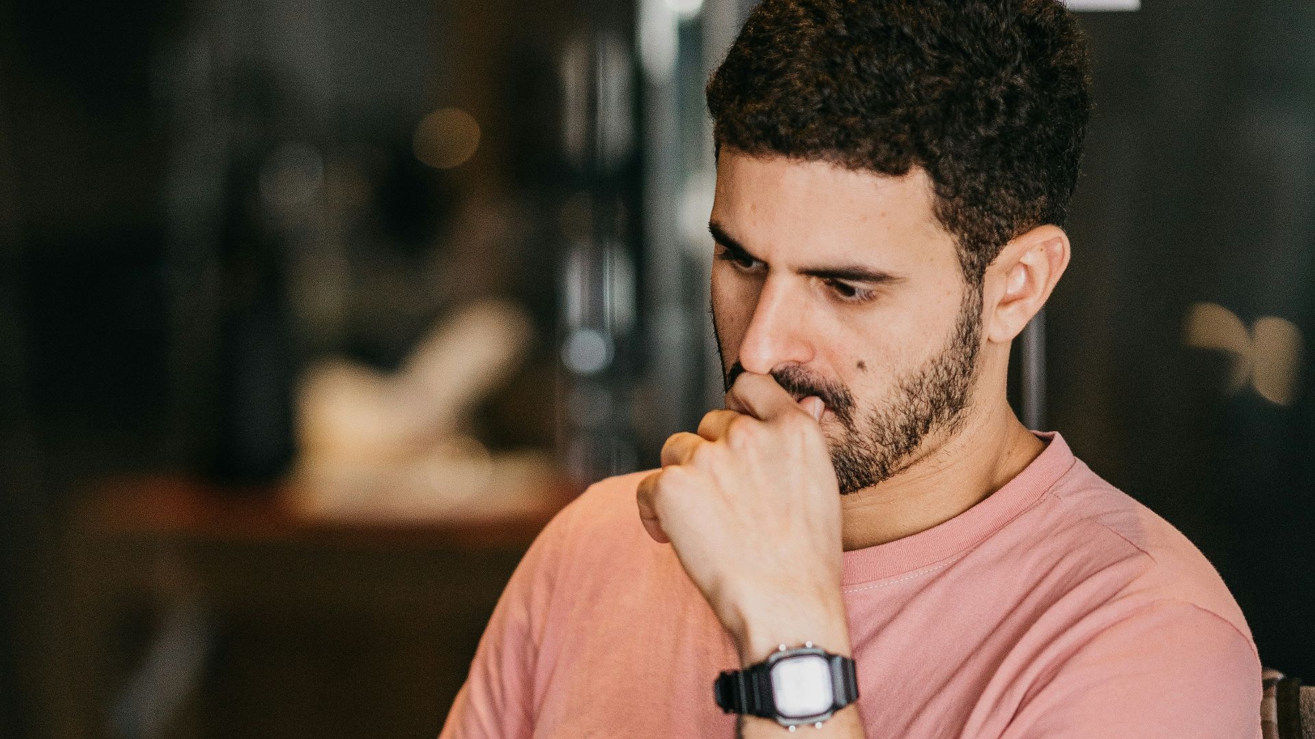 a man sitting at a table with a laptop and a cup