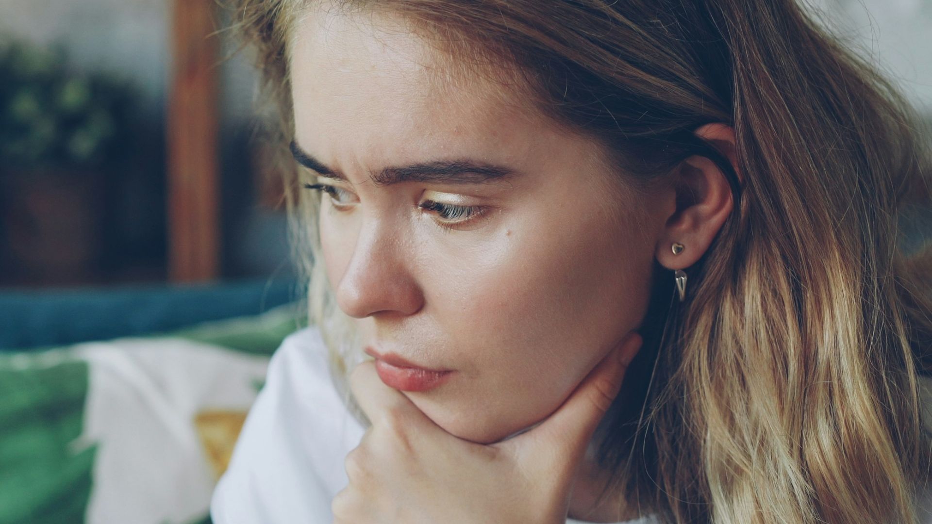 Young woman looking at a small object in her hand.