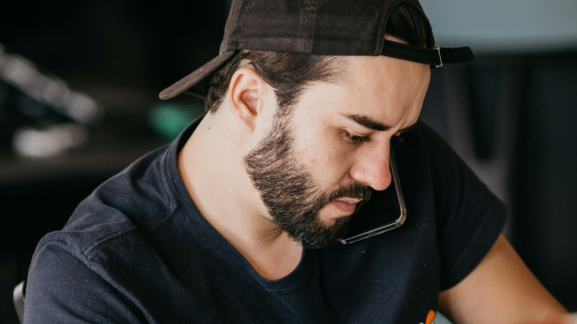 a man with a beard looking at a computer monitor