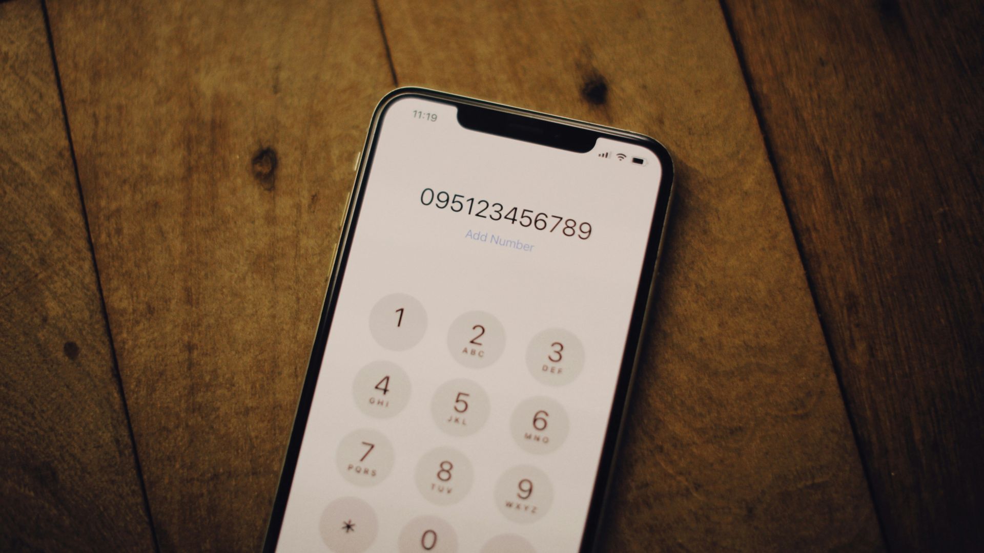 a cell phone sitting on top of a wooden table