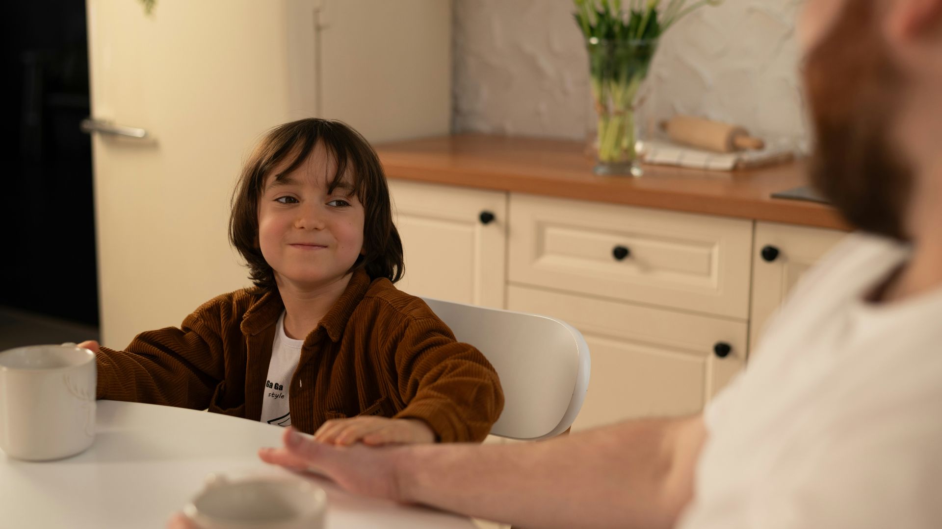 a little girl sitting at a table with a man