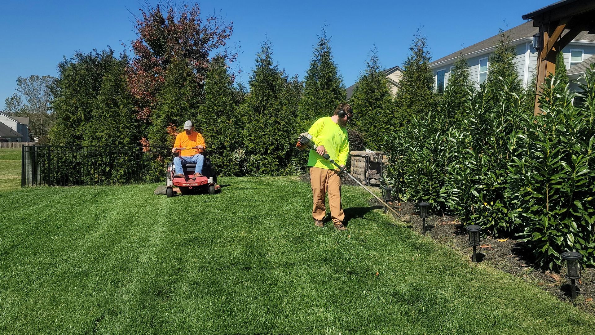 A man mowing a lawn with a lawn mower