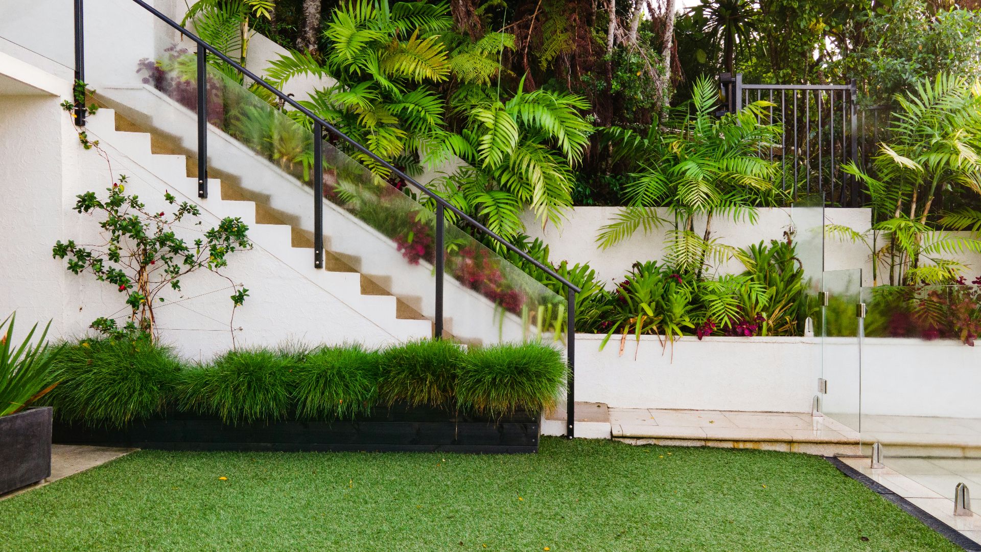 a white house with a green lawn and stairs