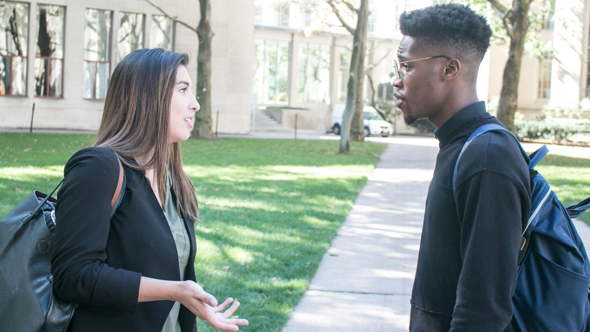 a man standing next to a woman on a sidewalk
