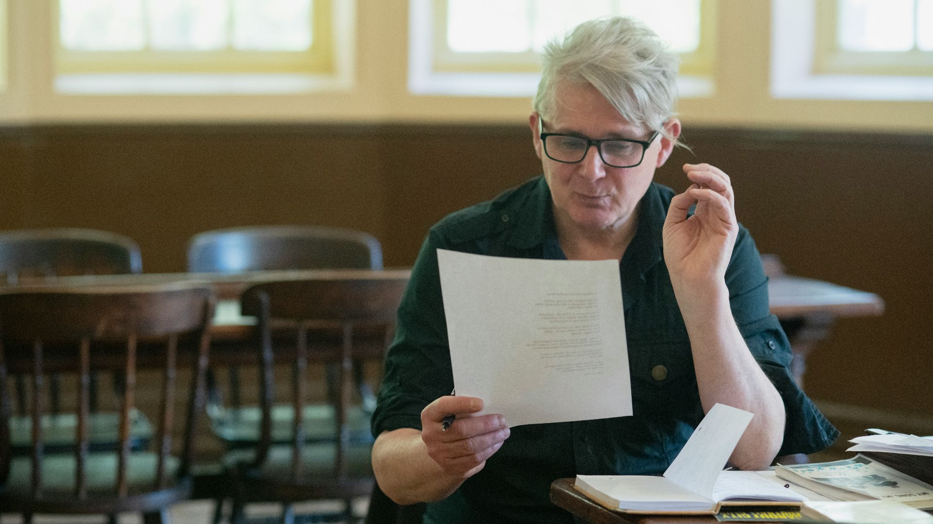 a man sitting at a table holding a piece of paper