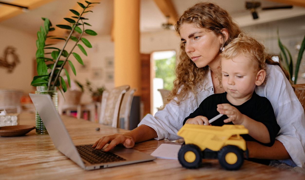 A Woman using a Laptop with her Son