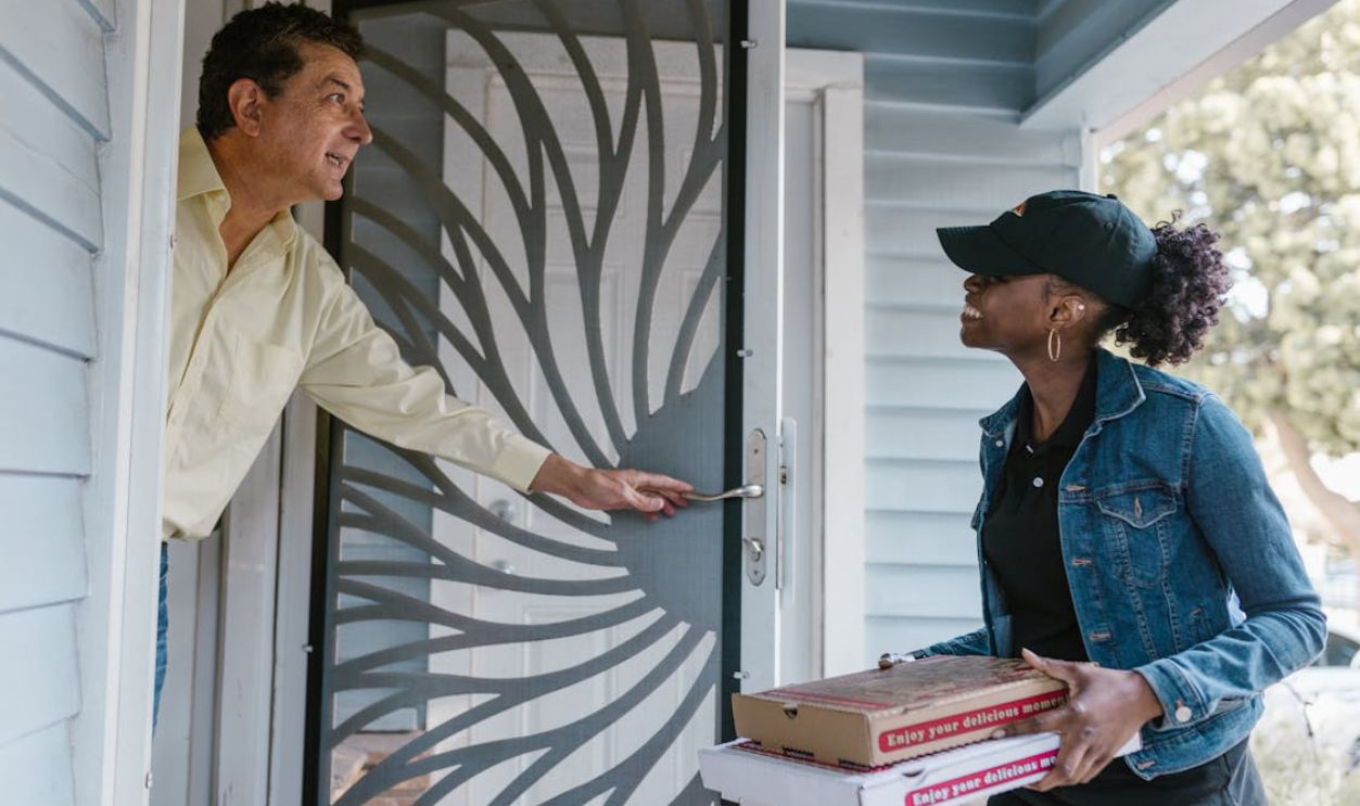 A Woman Delivering Boxes of Pizza