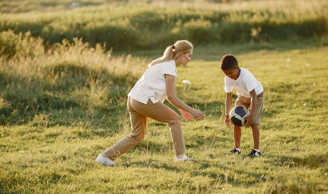 Woman and a Boy Playing Football