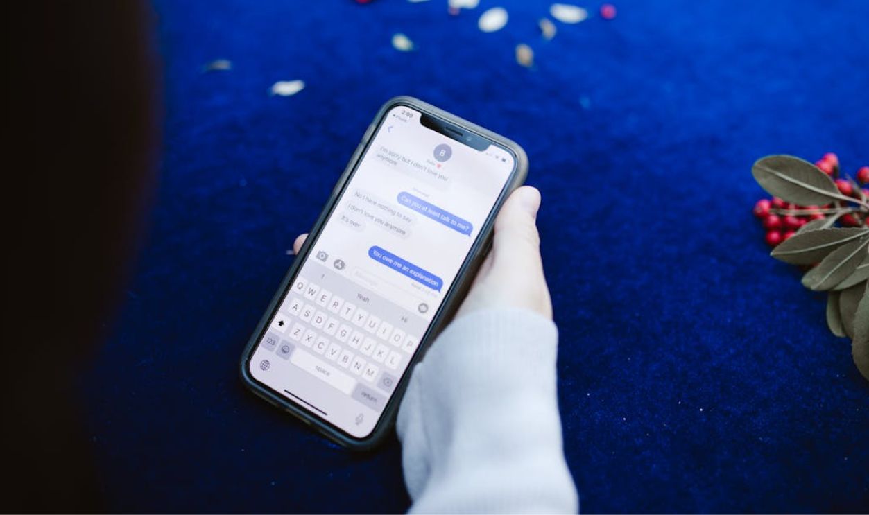 Person's Hand Showing Text Messages on Cellphone