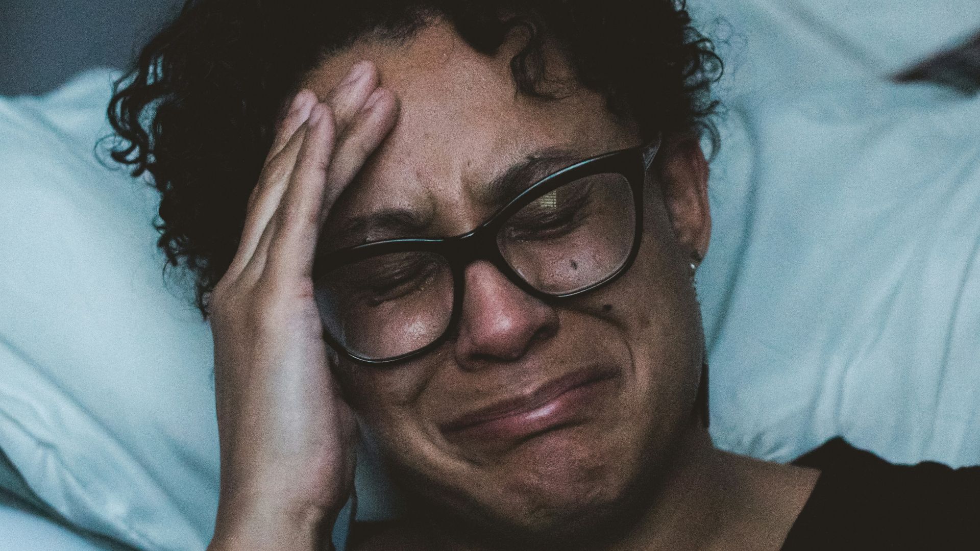 person crying beside bed