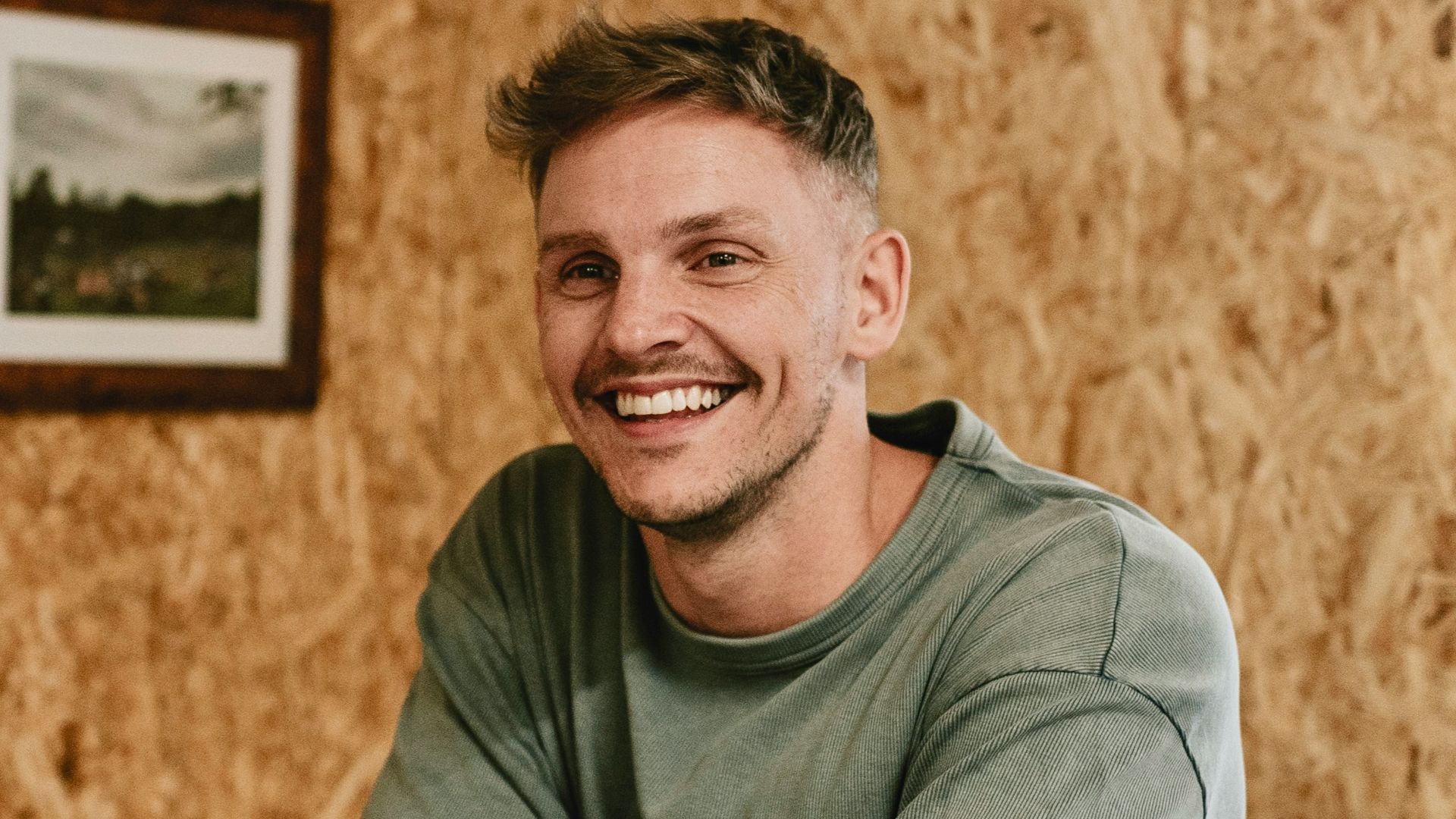 A man sitting at a table with a pool cue in his hand