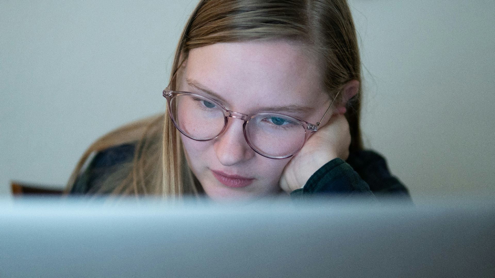 girl in blue jacket wearing brown framed eyeglasses