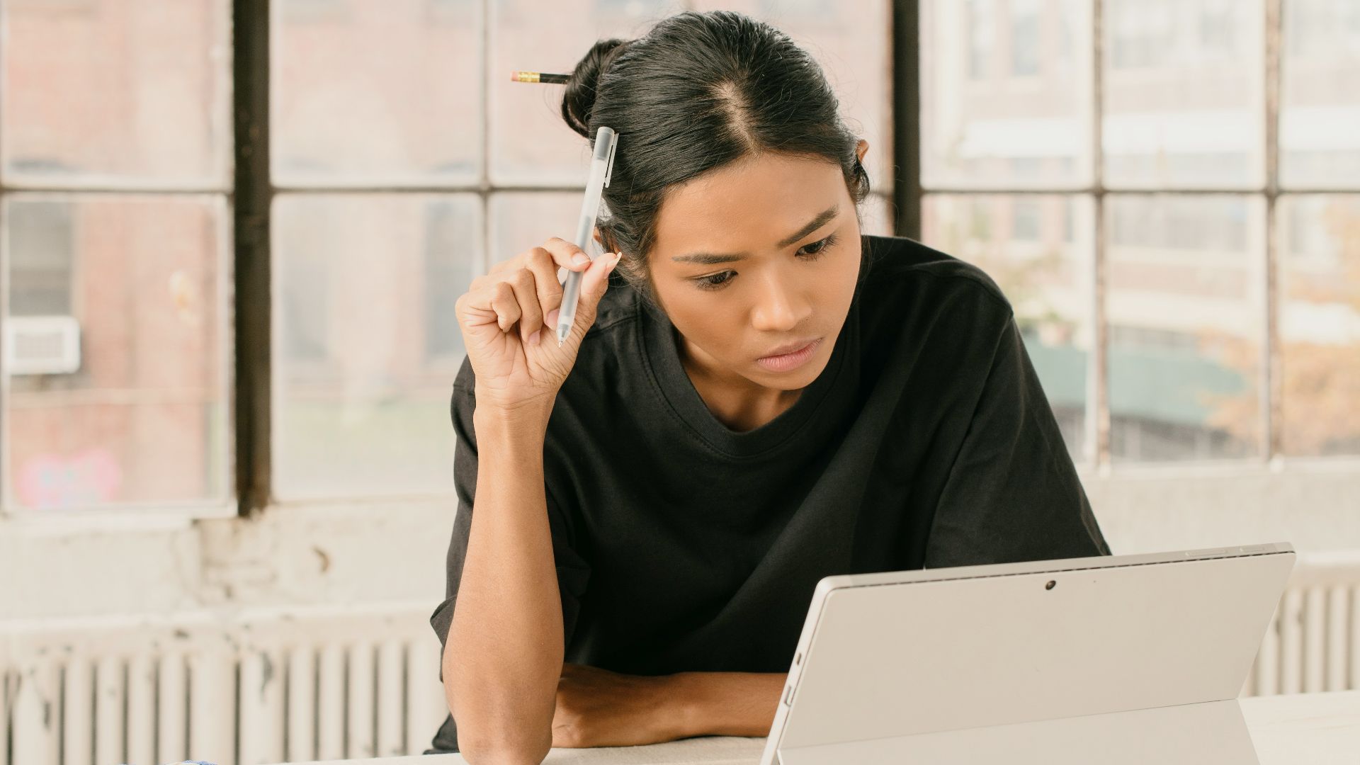 a woman sitting at a table using a laptop computer