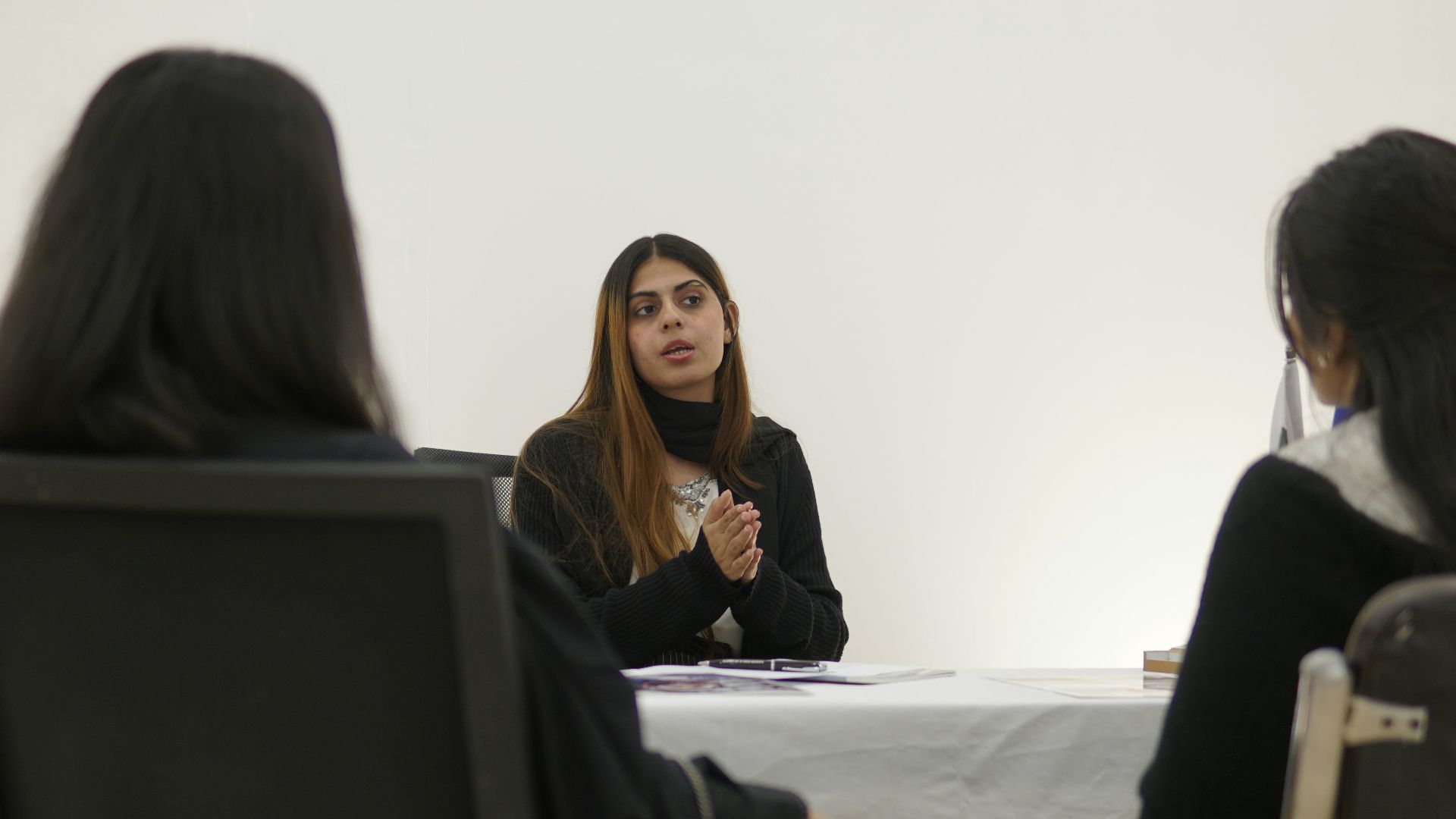 Woman speaking to two people across table