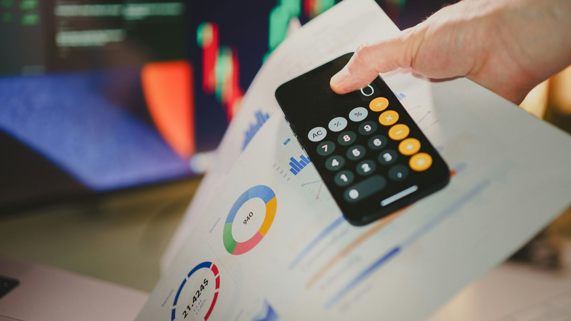 a person holding a calculator over a piece of paper