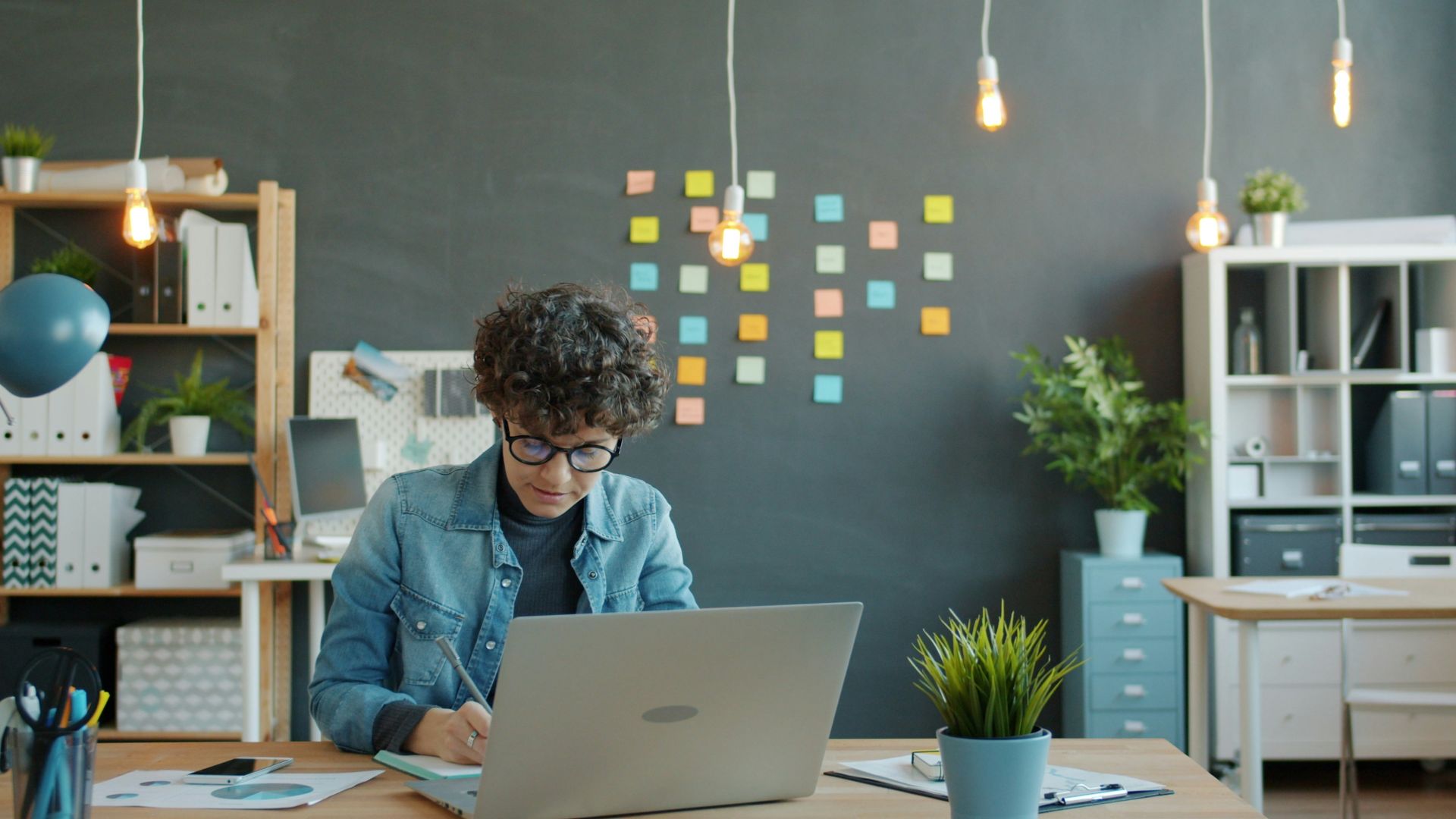 Young person working on a laptop in a modern office.