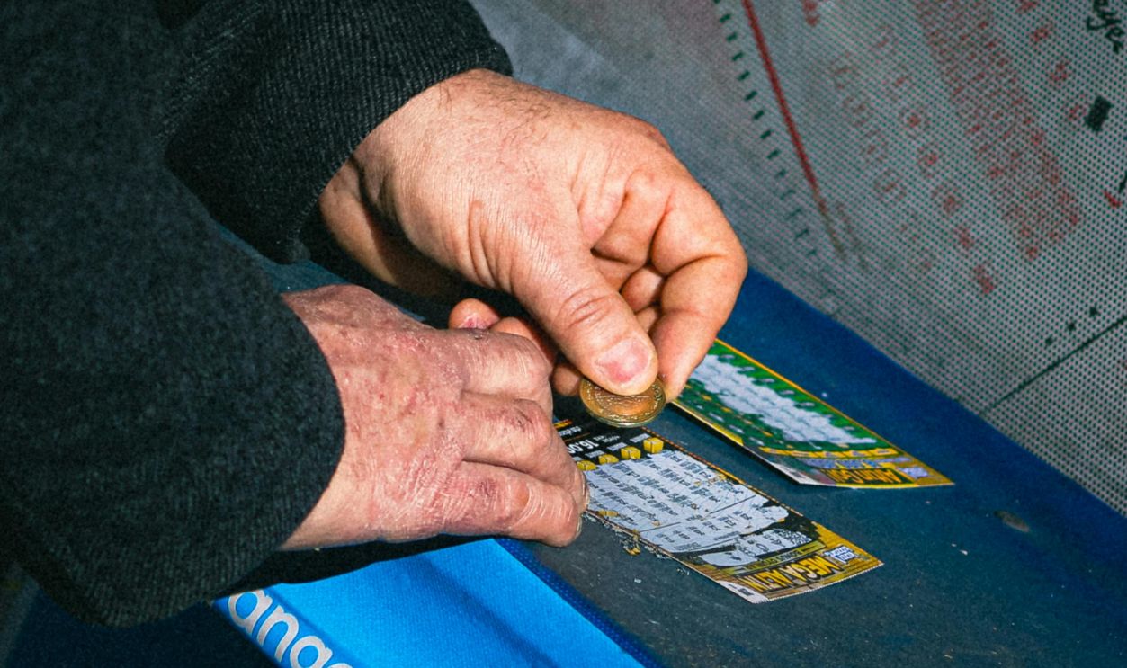 Close-up of hands scratching lottery tickets