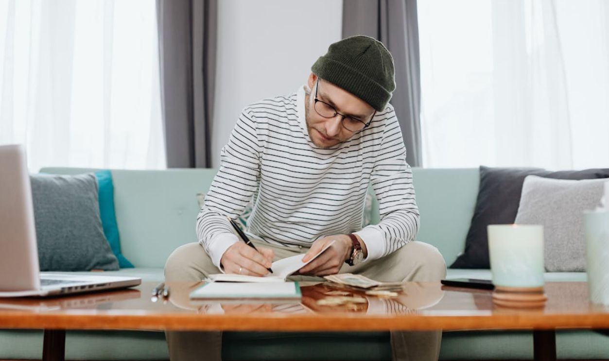 Woman in White and Black Stripe Long Sleeve Shirt Sitting on Blue Couch