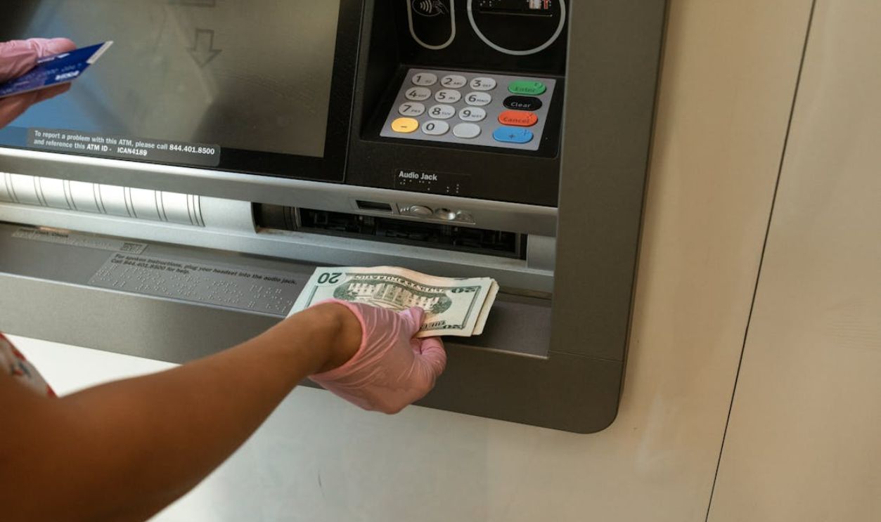 Person Deposits Money on an ATM
