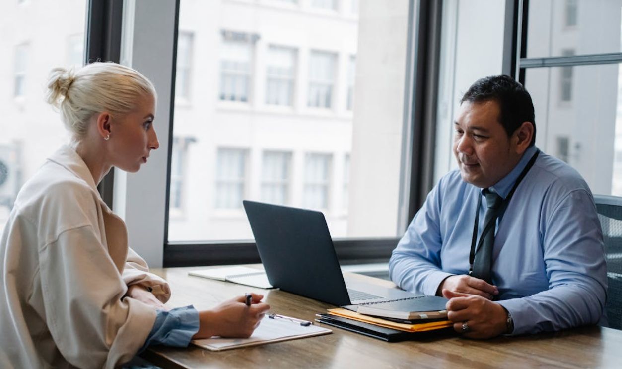 A person speaking with official at a desk