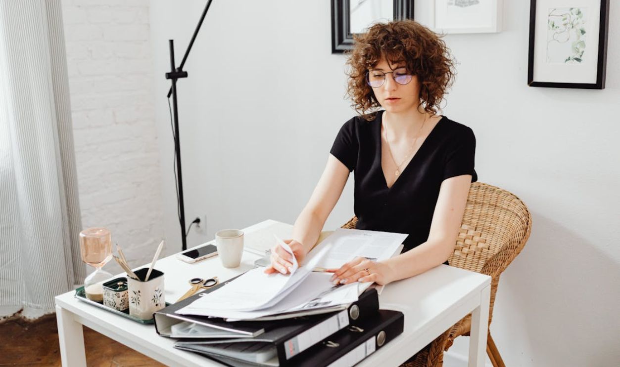 Woman Sitting by Table and Working