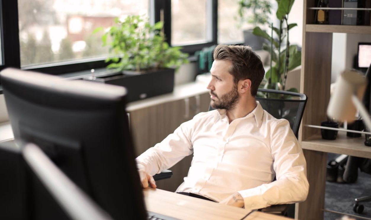 Man in White Shirt Sitting on Black Chair