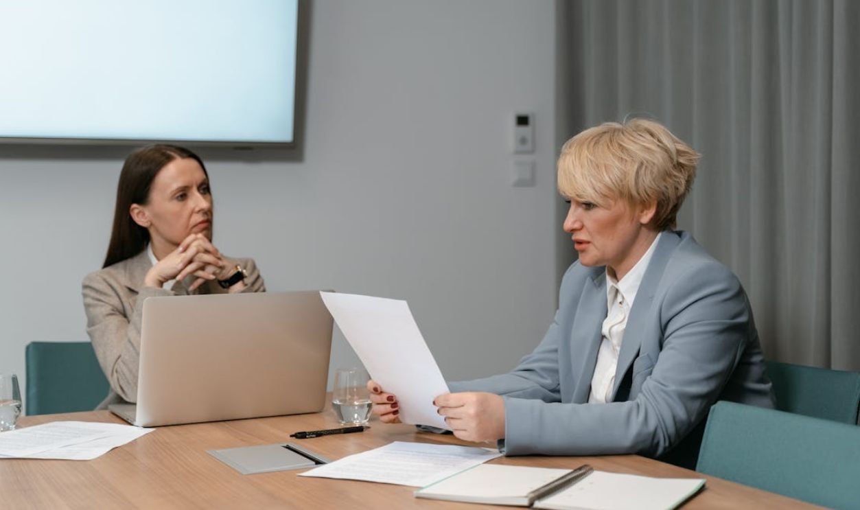 Two Women Sitting at Table with Laptop