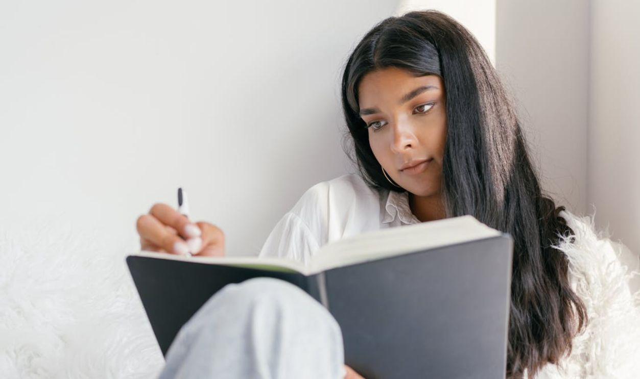 A Woman Writing on the Workbook