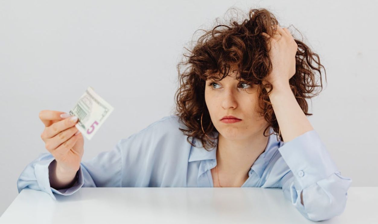 Curly-Haired Woman Holding a Paper Money