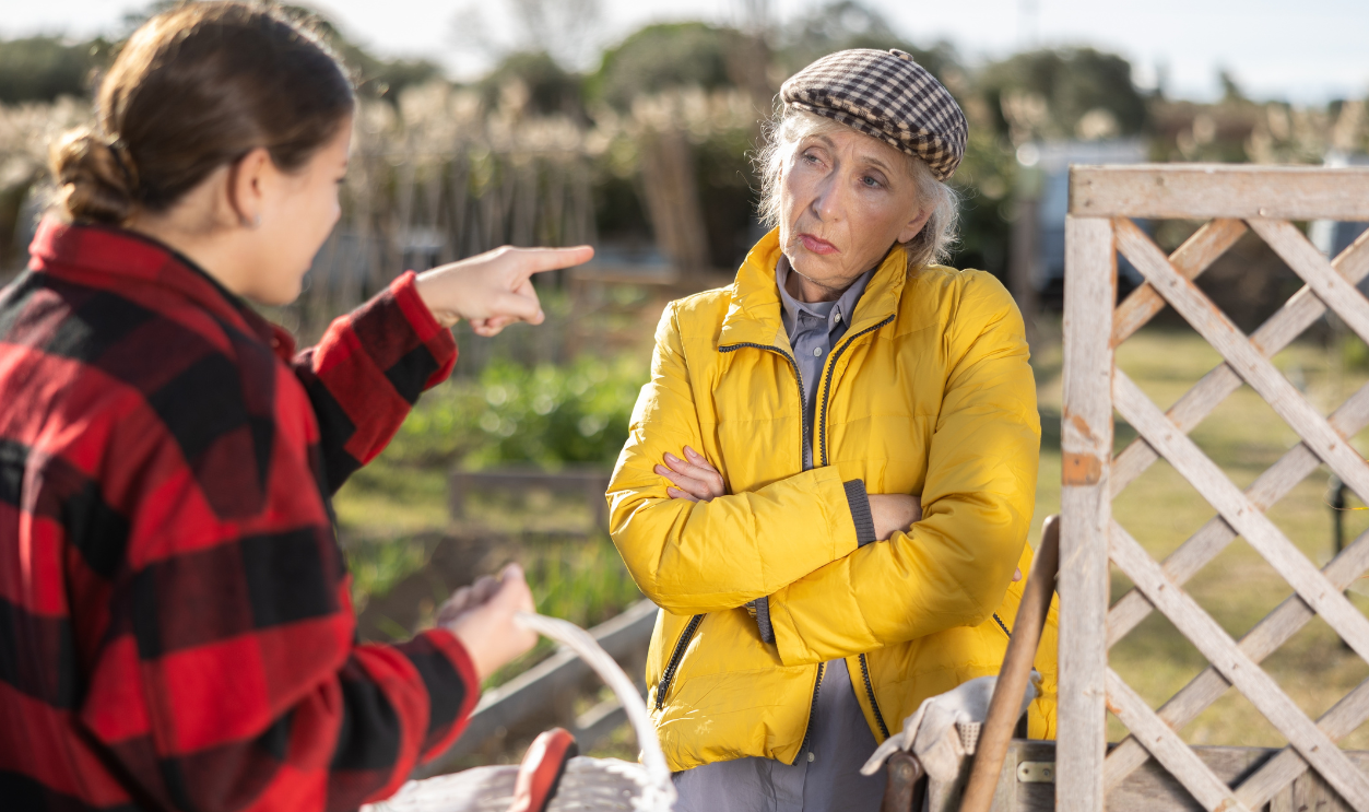 Two upset young and old female neighbors disagree