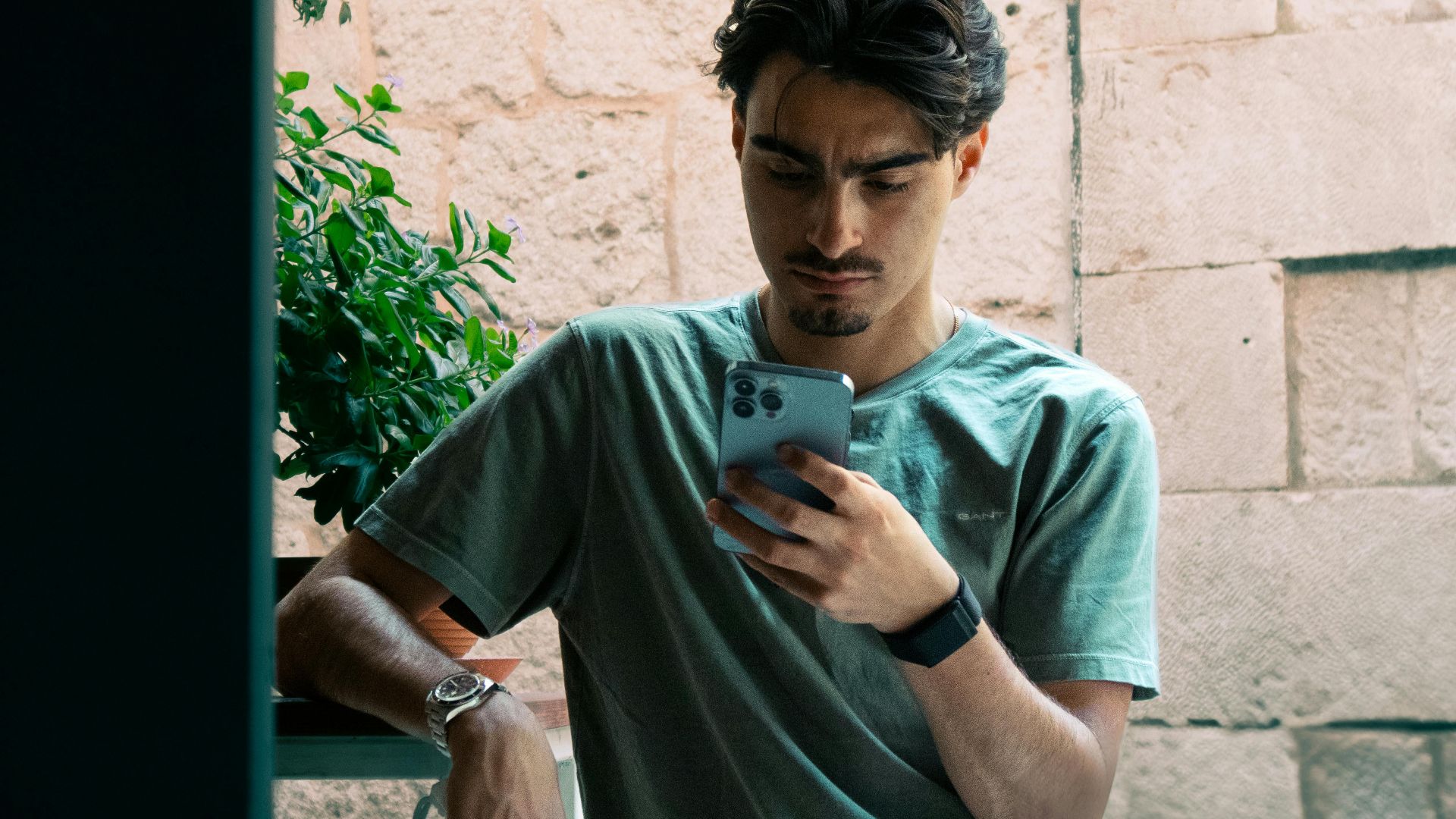 A young man in casual attire checking his phone outside in Split, Croatia.