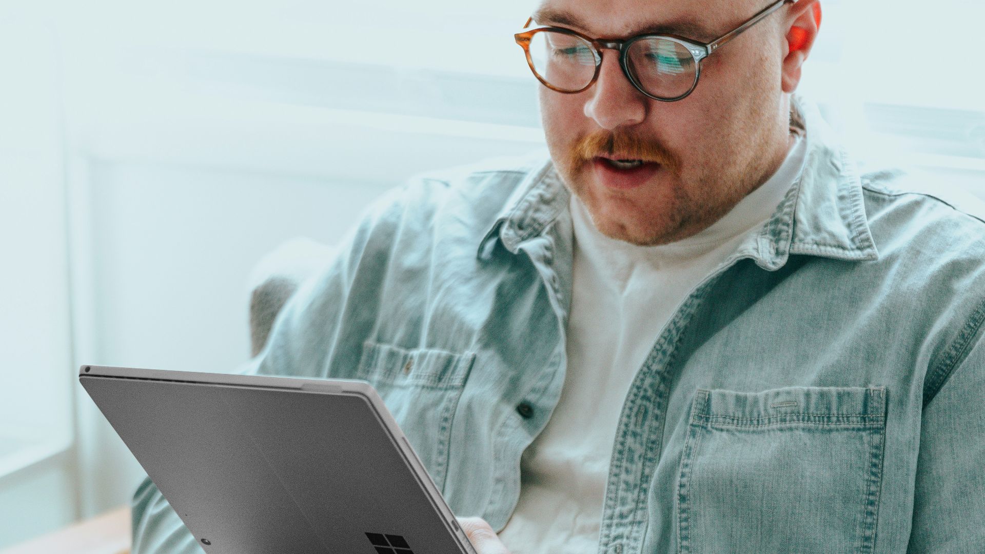 a man sitting on a couch using a laptop computer