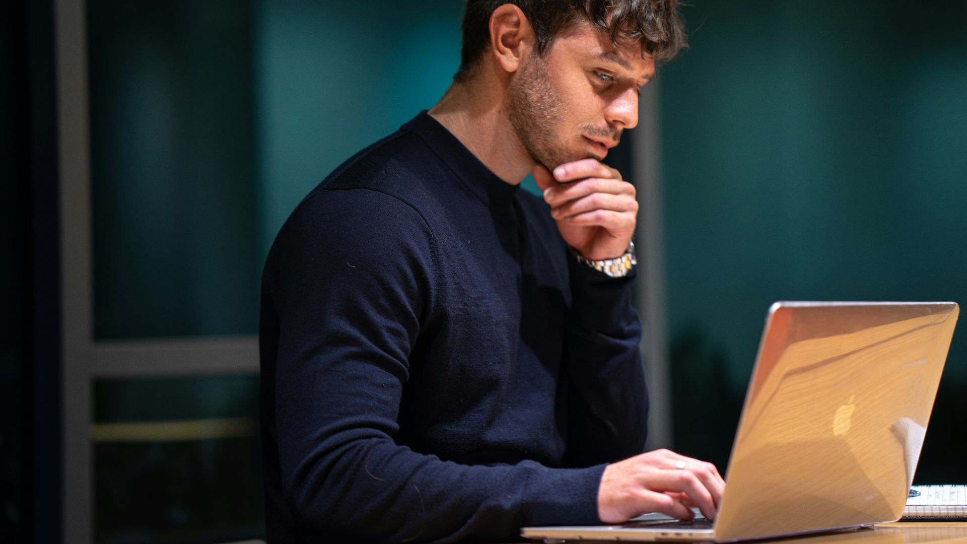 man in black long sleeve shirt sitting in front of macbook