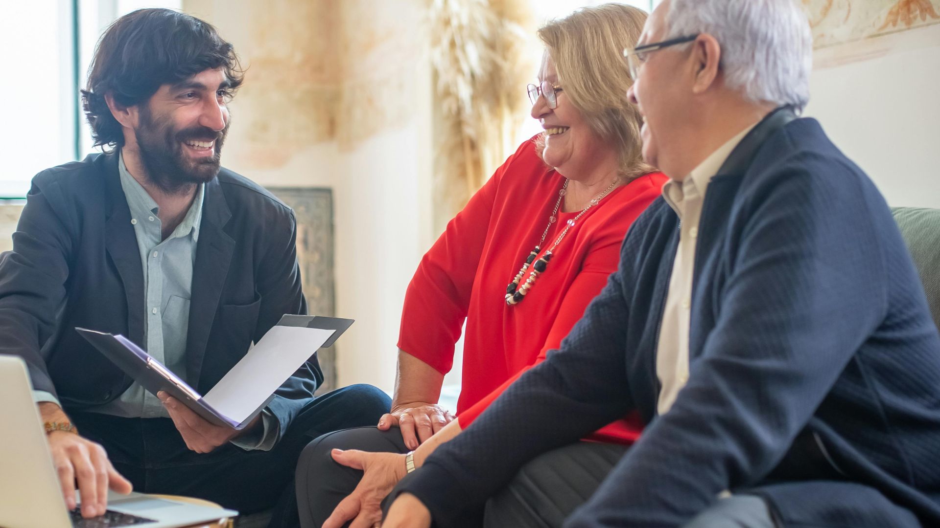 A professional business consultation with a senior couple and advisor indoors.