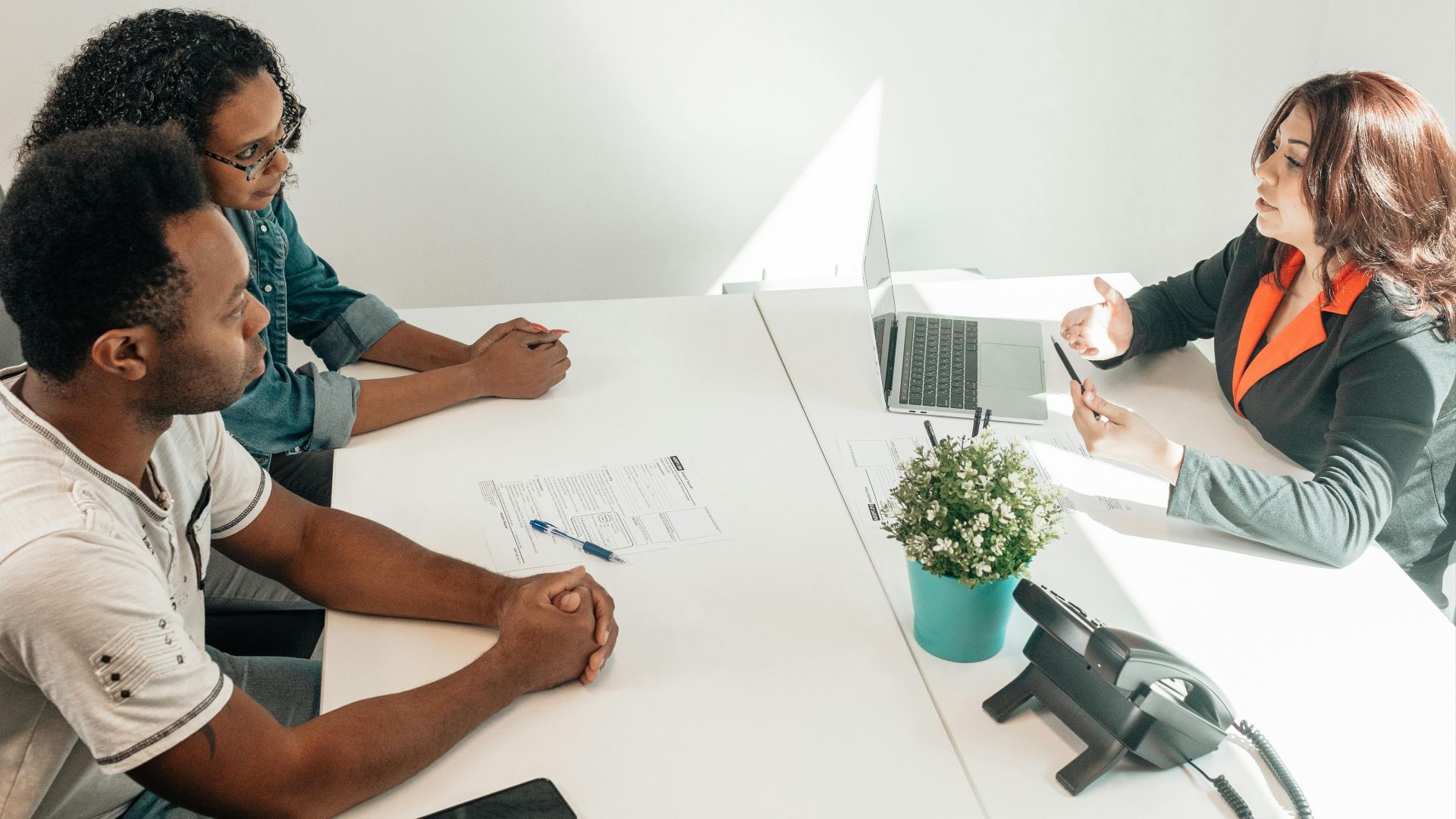 Two adults consulting a legal advisor in a modern office setting.