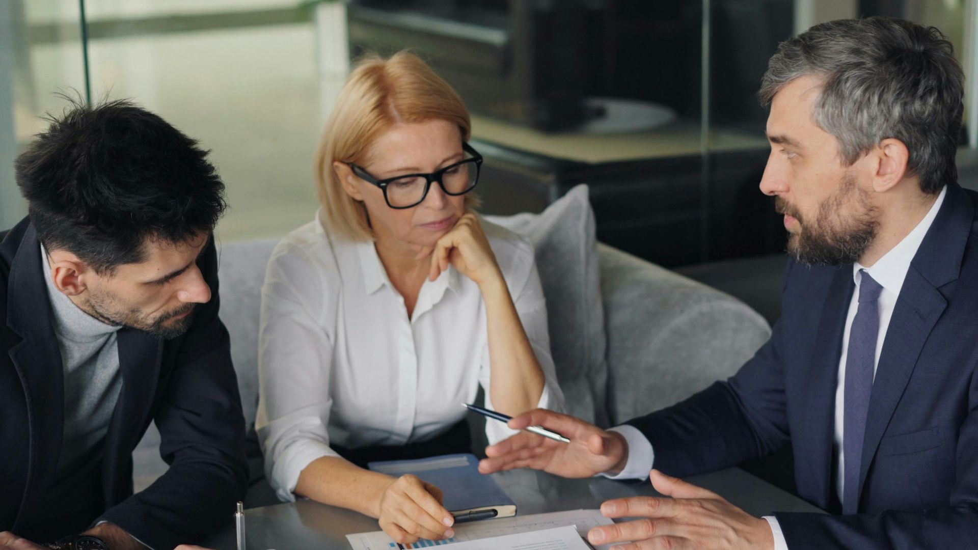 Professional colleagues engaged in a business meeting discussing strategy over coffee.