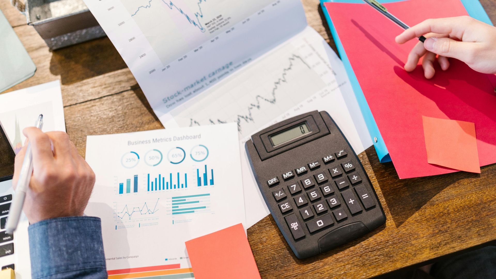 Financial analysis and planning tools with graphs and calculator on a table.
