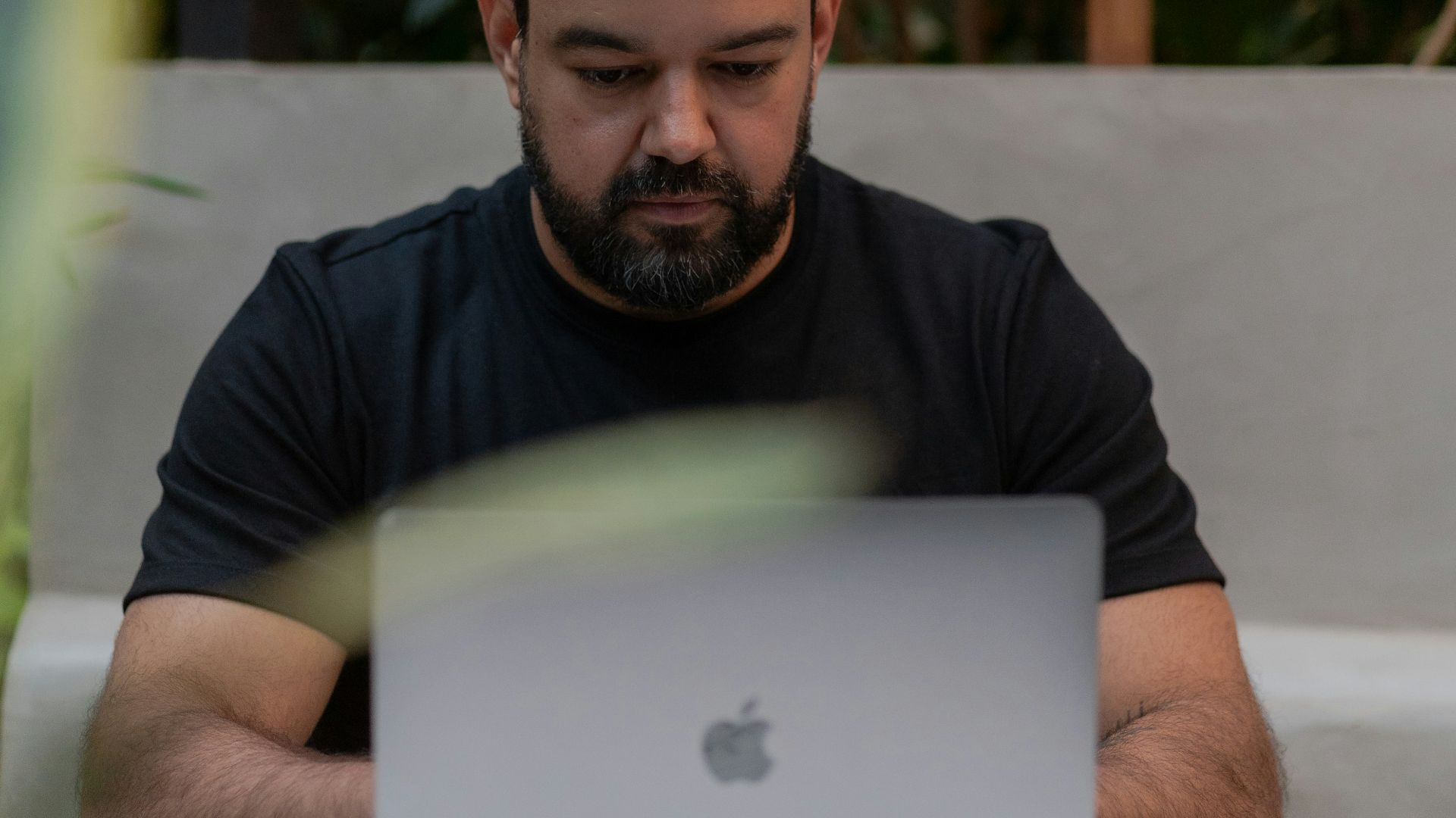 A man sitting at a table using a laptop computer