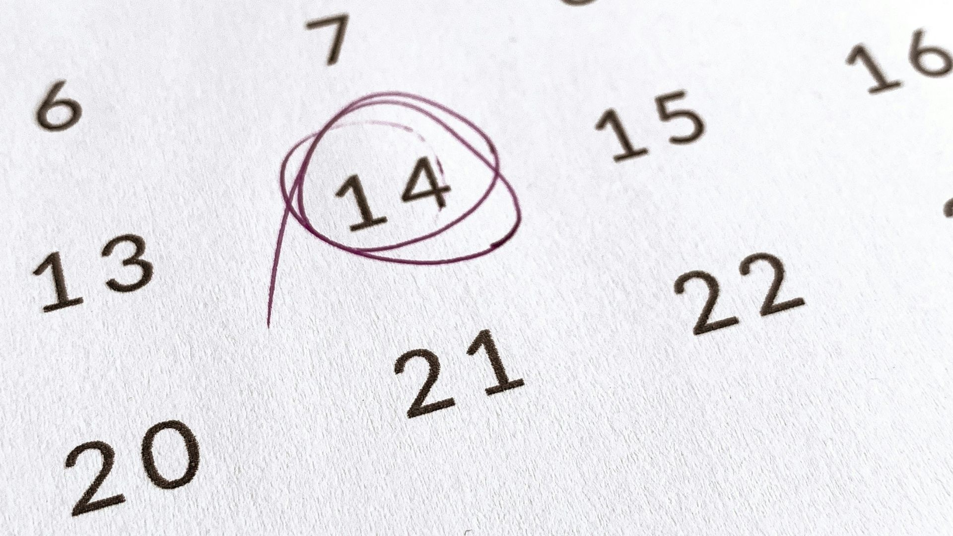 a close up of a calendar with a red marker