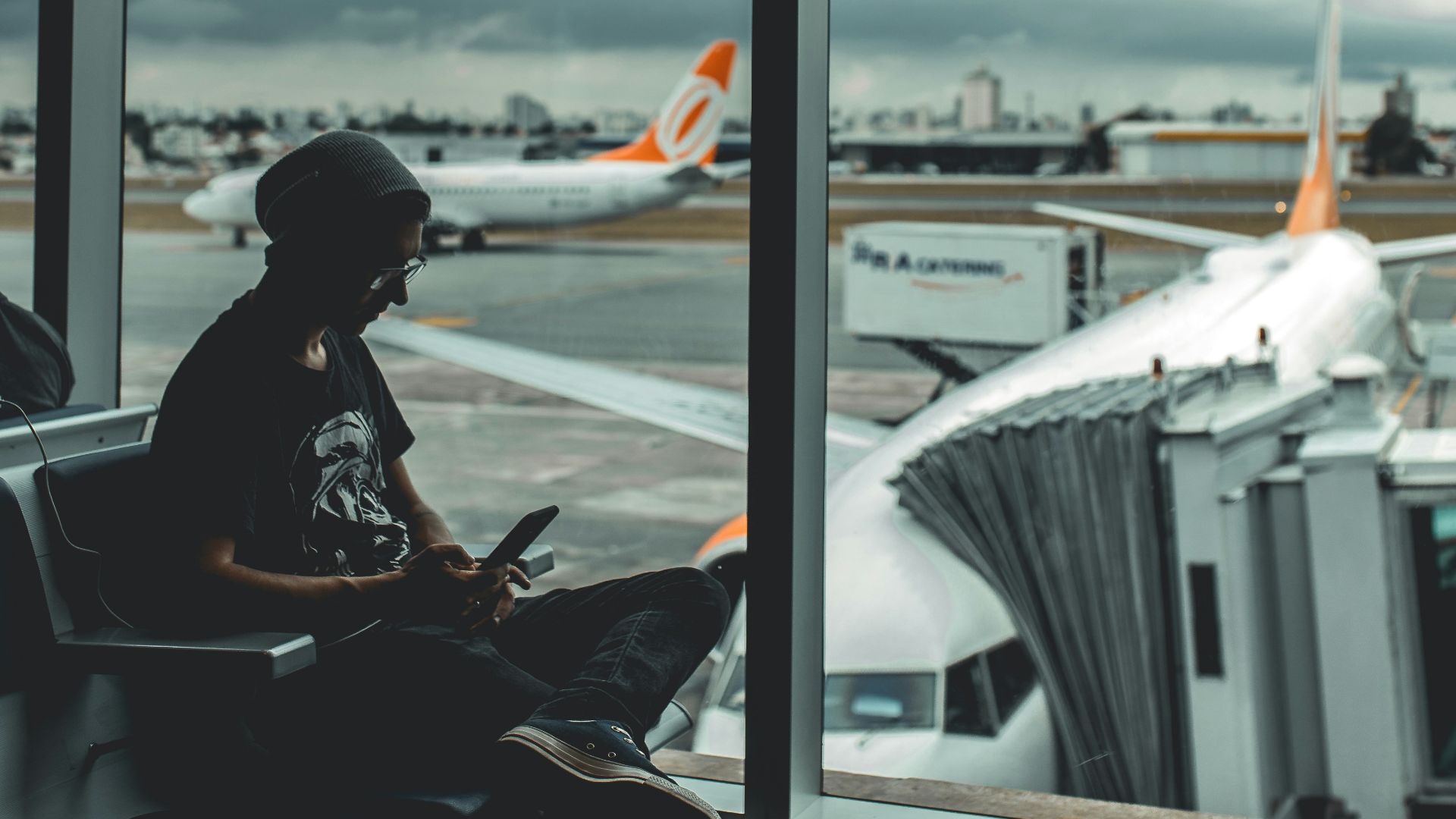 man browsing his phone in airport