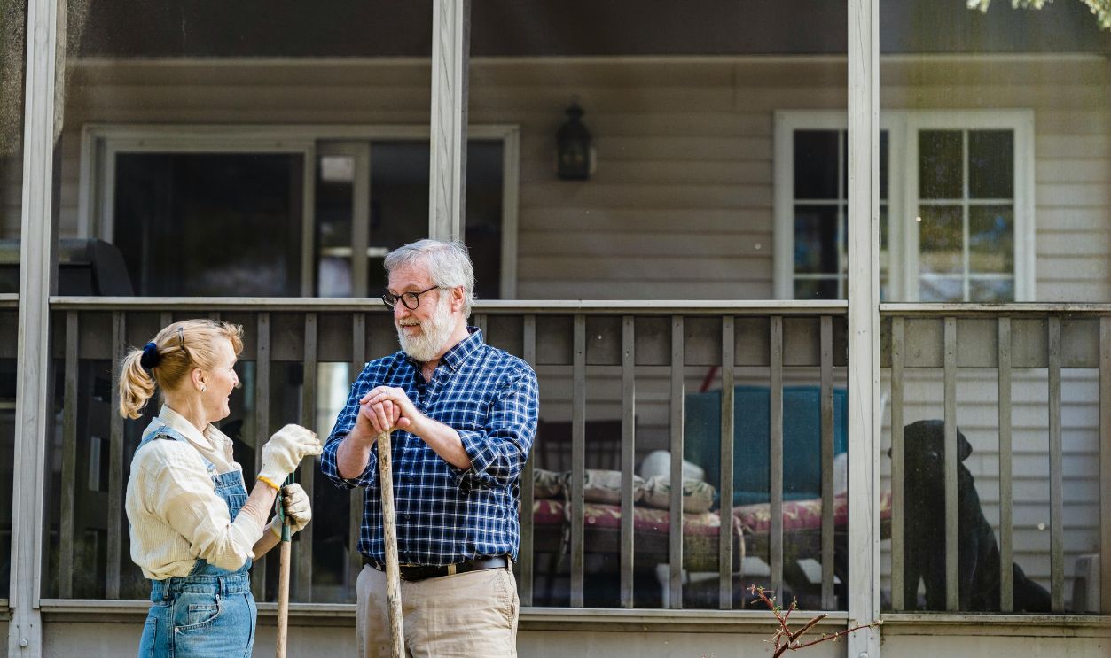 Senior couple gardening outside their home
