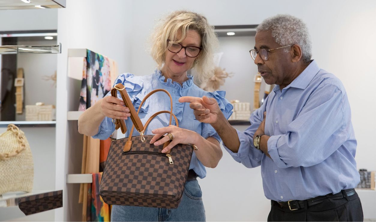 Senior couple browsing handbags in a stylish retail store