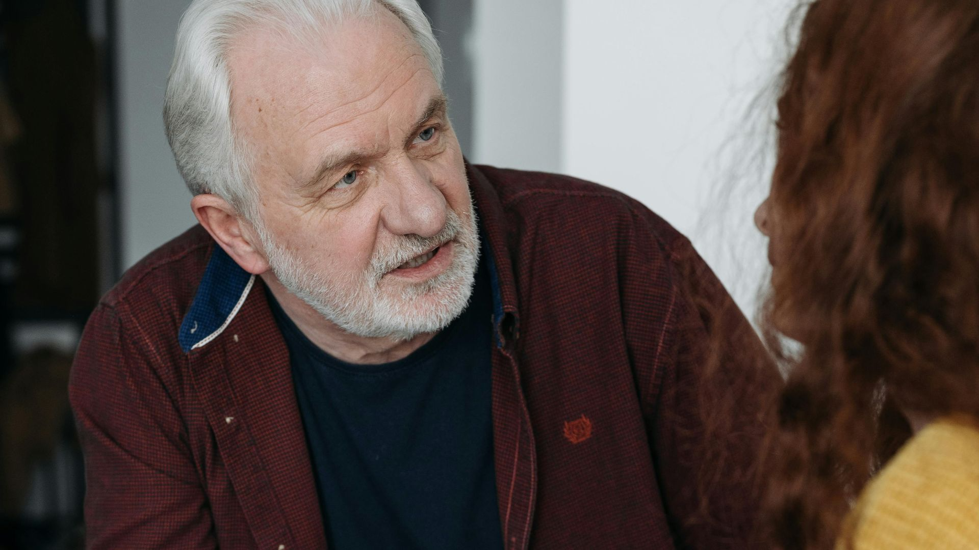 An elderly man and young woman discussing something important indoors