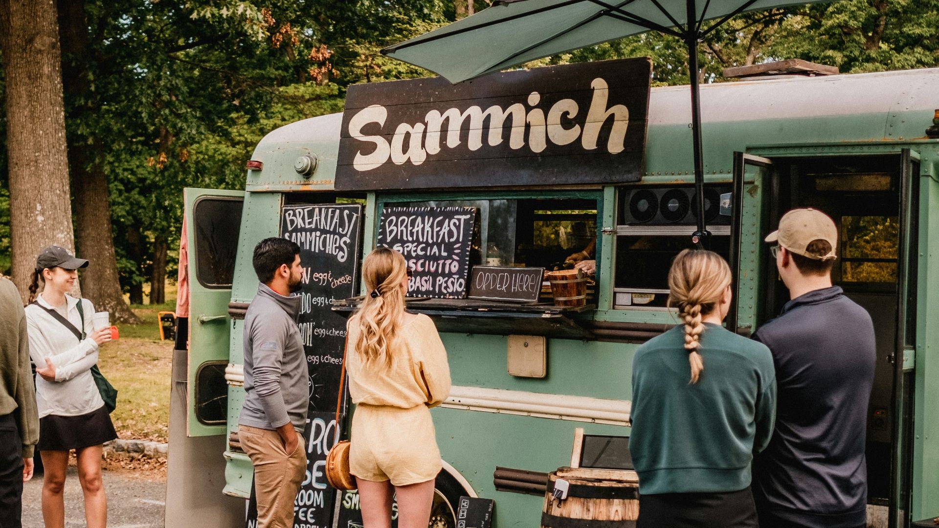 a group of people standing outside of a food truck