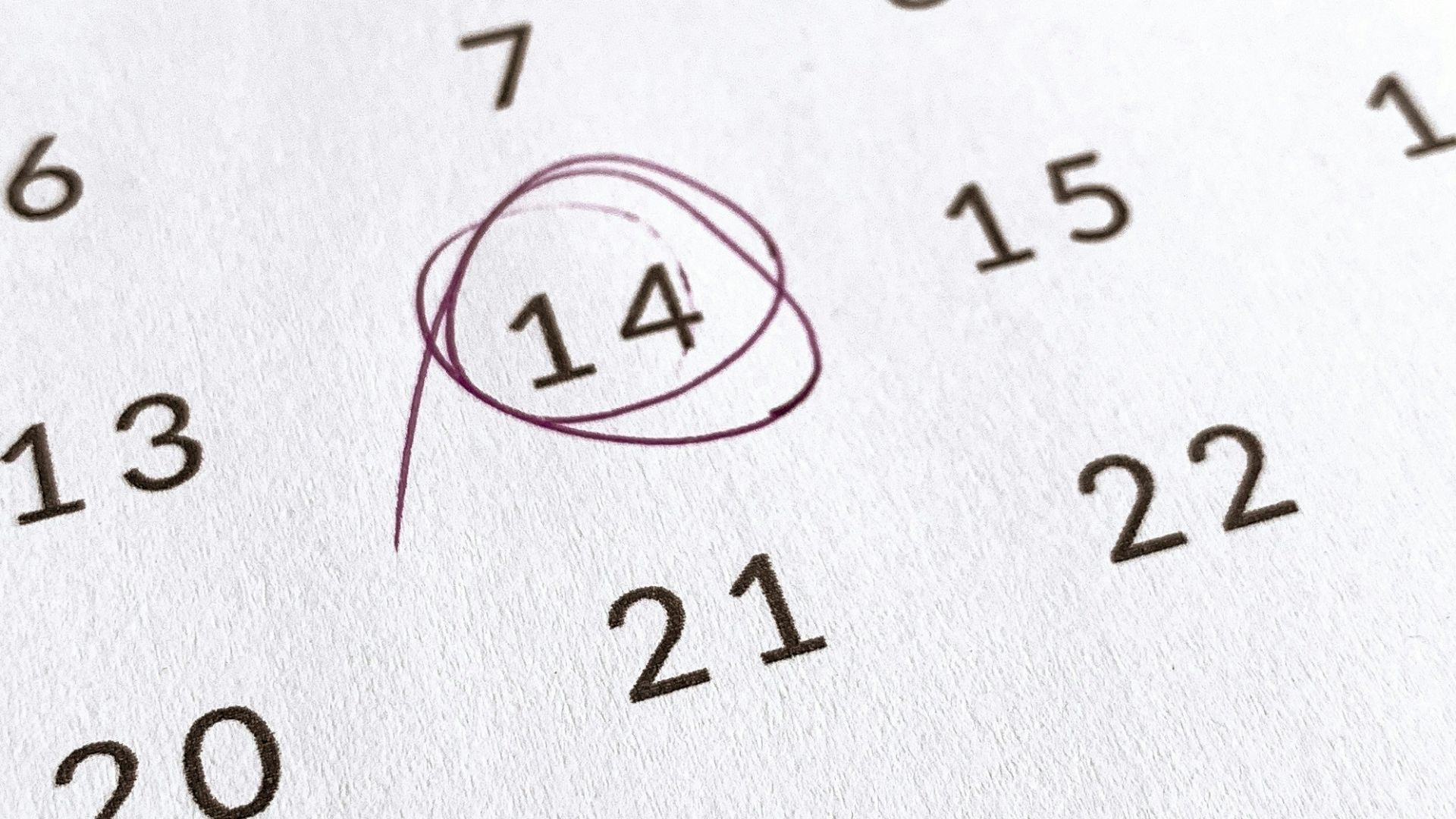 a close up of a calendar with a red marker