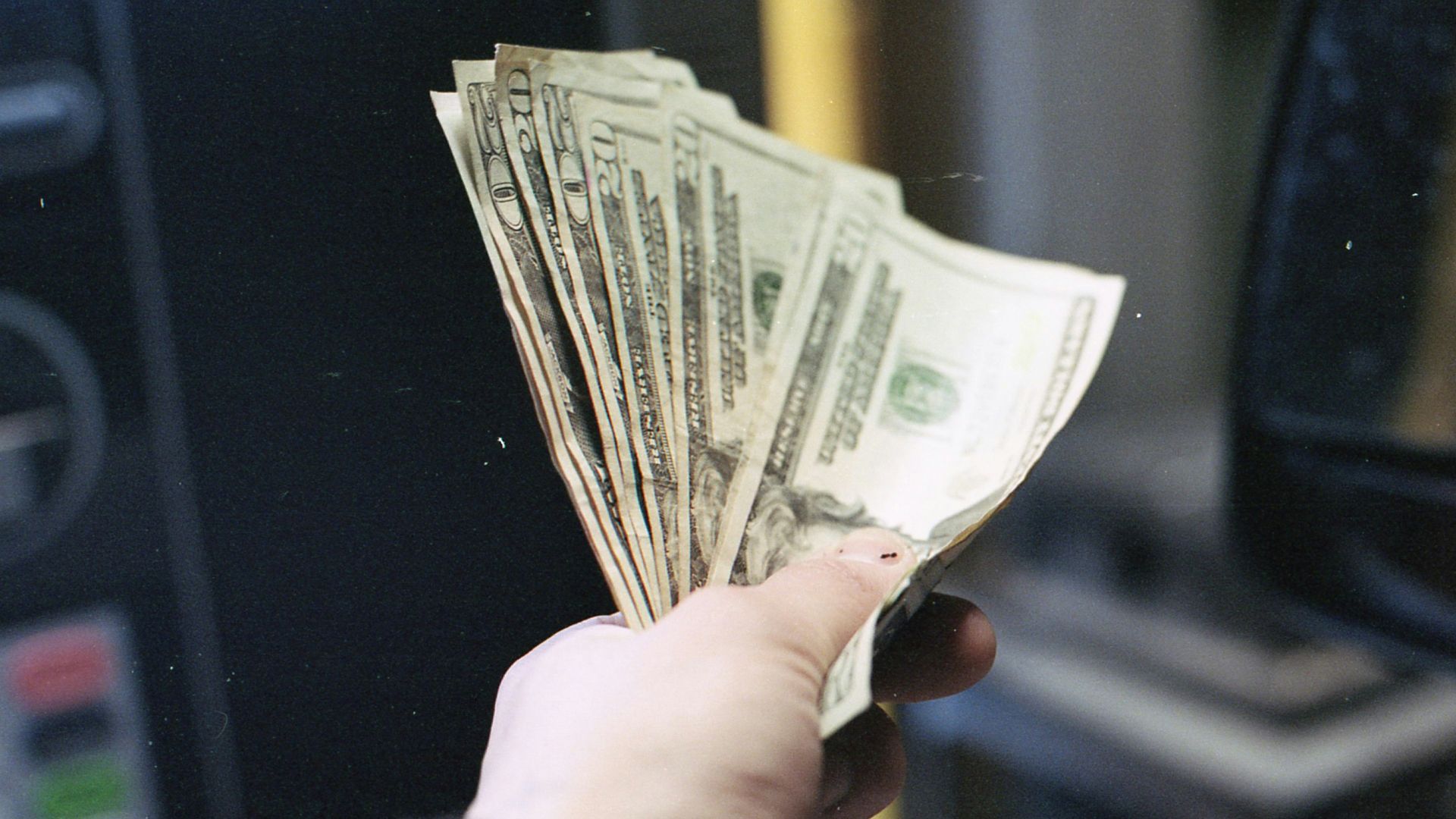 person holding fan of us dollar bill